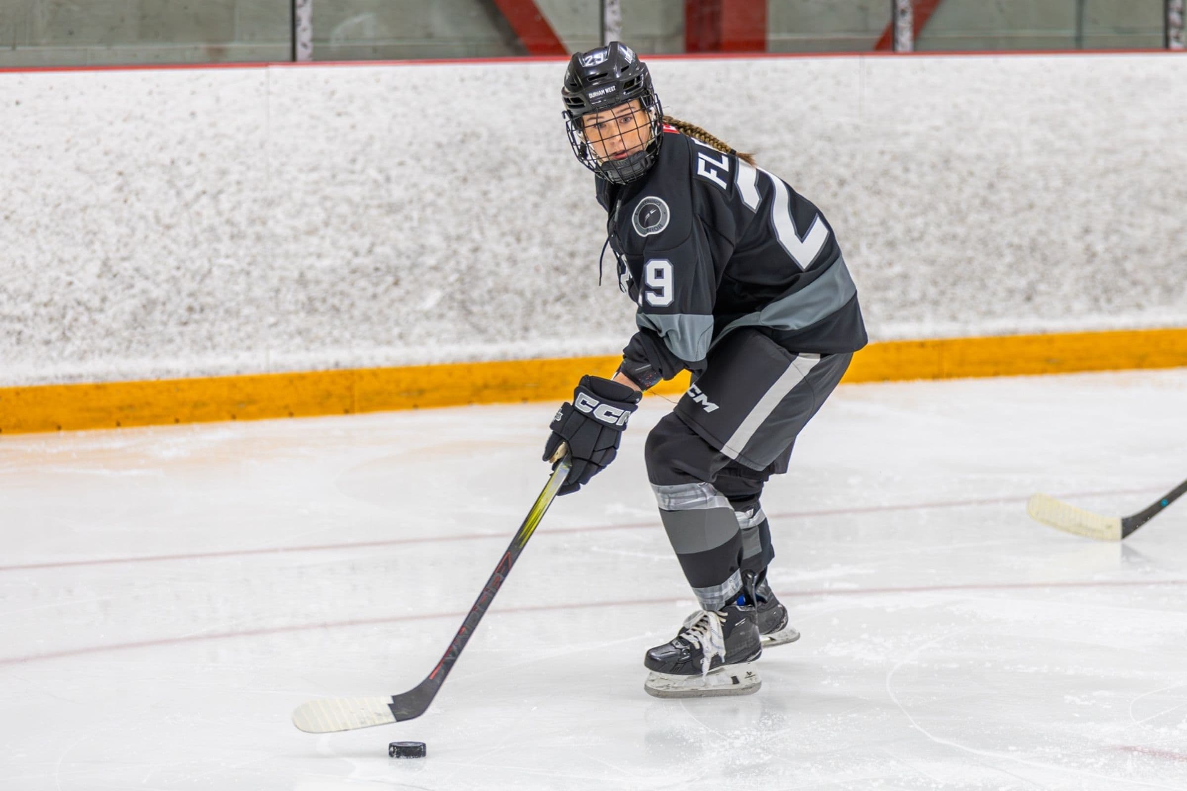 Lightning player number 29 controls the puck in the black jersey, looking up the ice