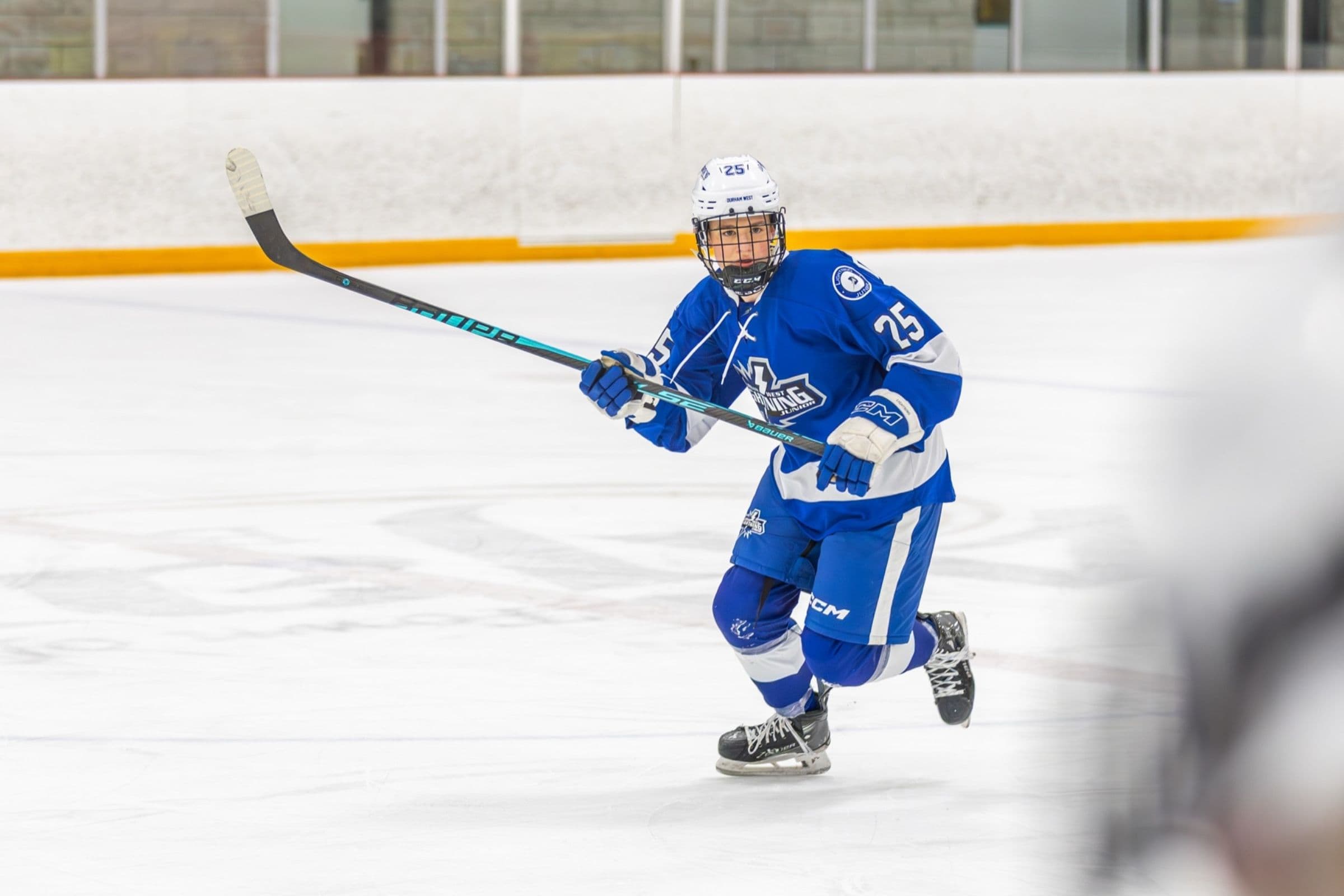 Lightning player number 25 strides hard up the ice in the blue home jersey