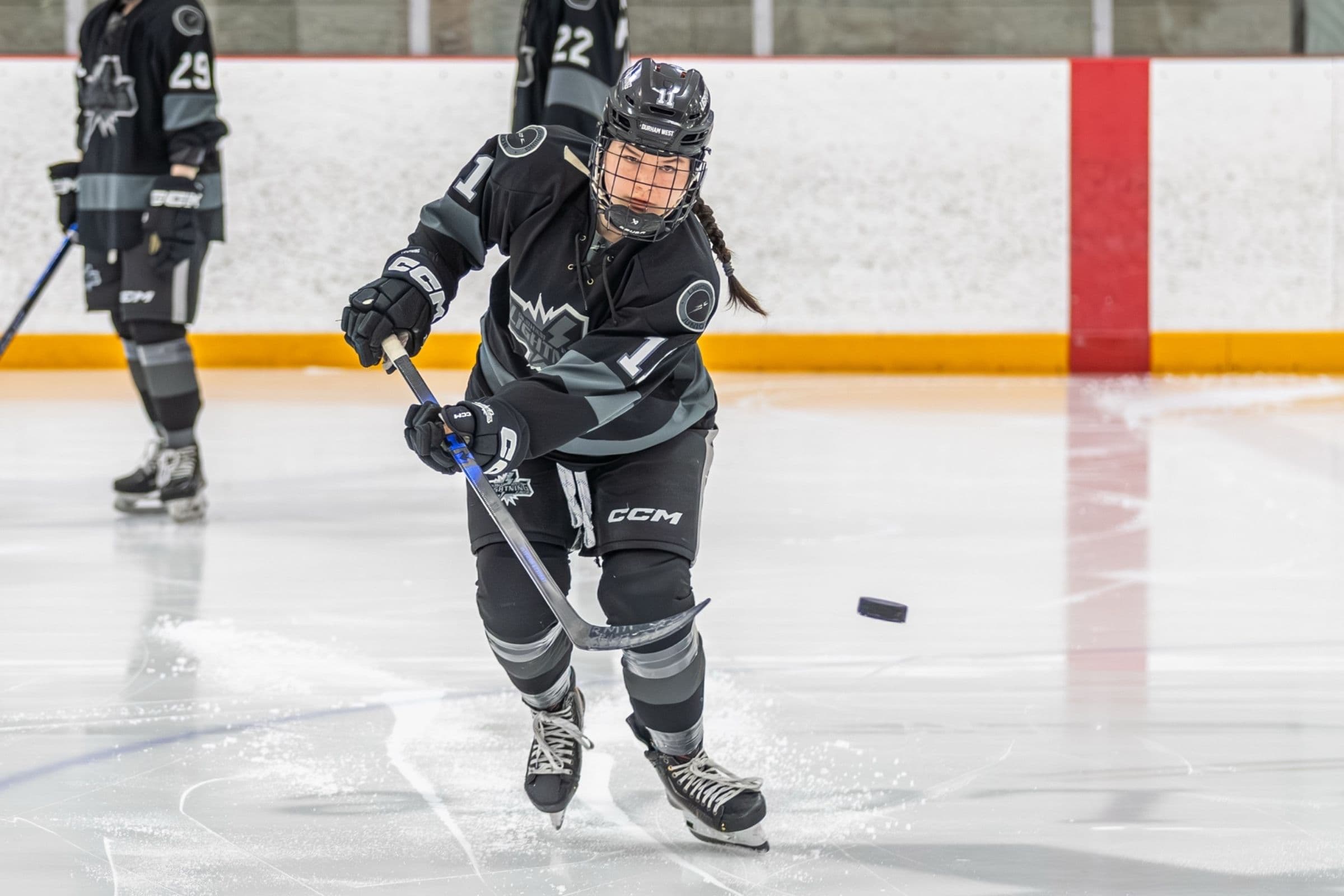 Lightning player number 1 snaps a pass in the black jersey as two teammates trail the play